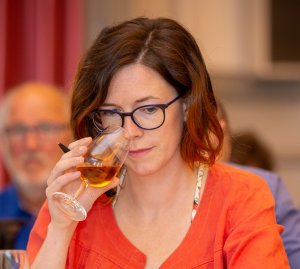 Une femme porte un verre de cidre à son nez