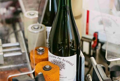 L'étiquetage d'une bouteille de cidre à la cidrerie de Cozmezou